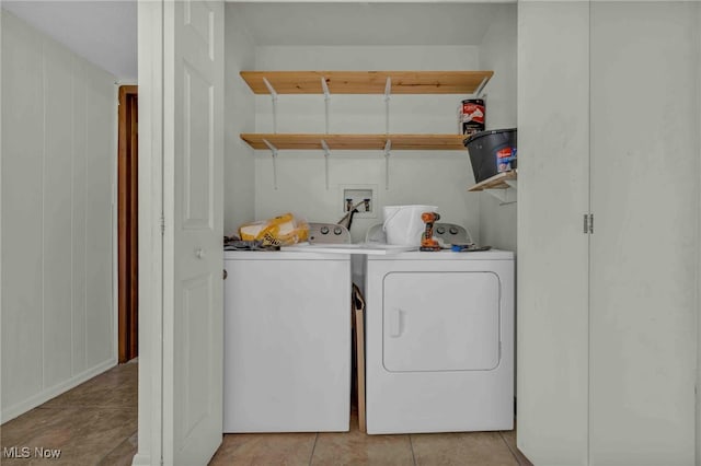 laundry room with washing machine and clothes dryer, light tile patterned flooring, and laundry area
