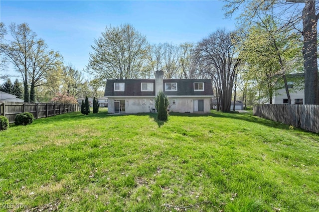 back of property with roof with shingles, fence, a yard, and a chimney