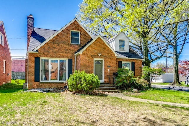 3860 Colony Rd, South Euclid, OH 44118 - view of front facade with brick siding, a shingled roof, a front lawn, and a chimney