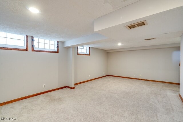 below grade area with baseboards, carpet, recessed lighting, and visible vents