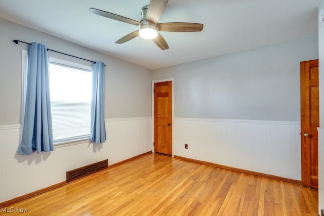 3860 Colony Rd, South Euclid, OH 44118 - unfurnished room featuring visible vents, ceiling fan, wood finished floors, and a wainscoted wall