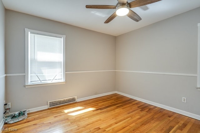 unfurnished room featuring baseboards, ceiling fan, wood finished floors, and visible vents