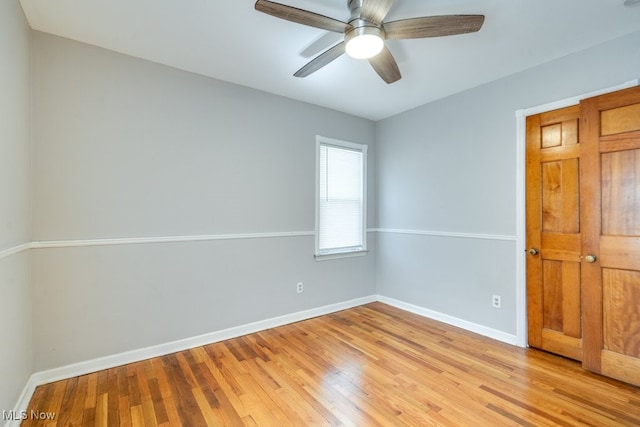 spare room with baseboards, ceiling fan, and light wood-style flooring