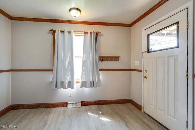 entrance foyer featuring crown molding, baseboards, wood finished floors, and visible vents