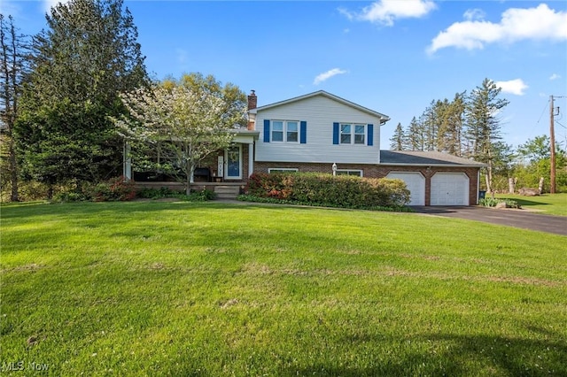 split level home with a chimney, a garage, brick siding, aphalt driveway, and a front lawn
