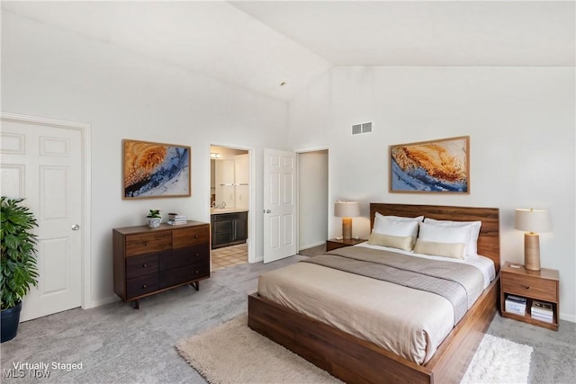 bedroom featuring visible vents, baseboards, high vaulted ceiling, light colored carpet, and connected bathroom