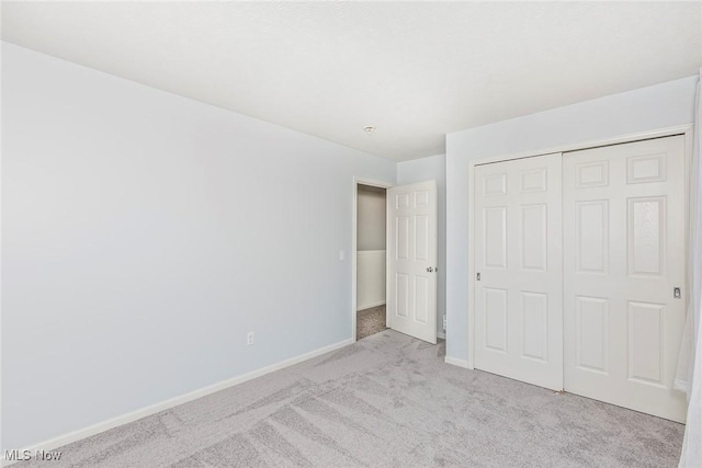 unfurnished bedroom with carpet floors, baseboards, and a closet