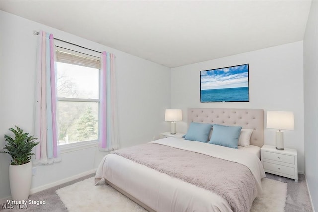 bedroom with baseboards and light carpet