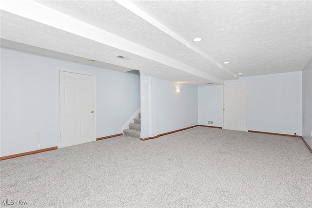 finished below grade area featuring a textured ceiling, carpet, stairs, recessed lighting, and baseboards