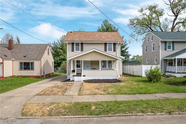 view of front of home featuring fence, a front lawn, a porch, and driveway