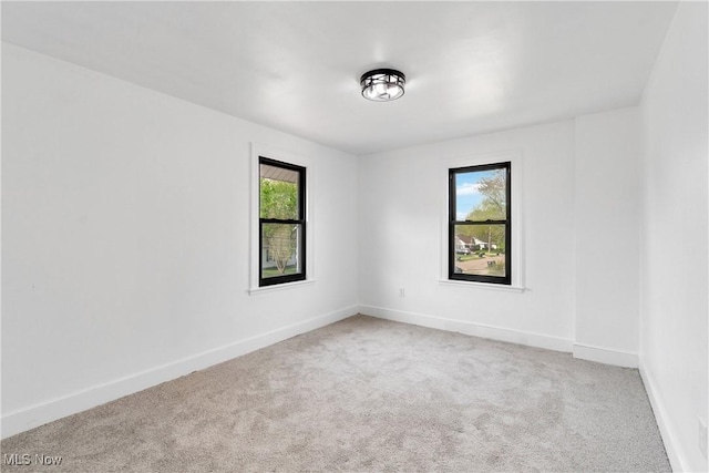 carpeted spare room featuring baseboards