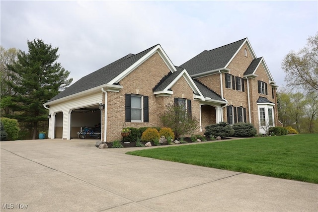 view of front of property featuring a garage, driveway, a front lawn, and brick siding
