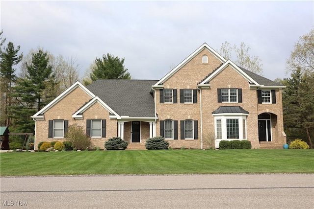 view of front of home featuring a front lawn and brick siding