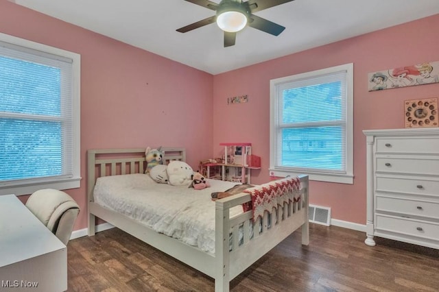 bedroom with baseboards, visible vents, multiple windows, and wood finished floors