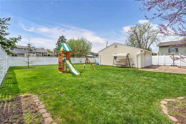 view of yard with a patio, a fenced backyard, a playground, and an outbuilding