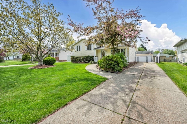 split level home featuring a detached garage, a gate, and a front yard
