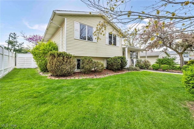 split level home with fence and a front lawn
