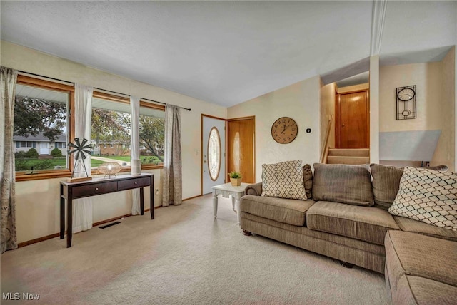 carpeted living area with baseboards, vaulted ceiling, and visible vents