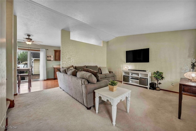 living area with light colored carpet, a ceiling fan, baseboards, and vaulted ceiling