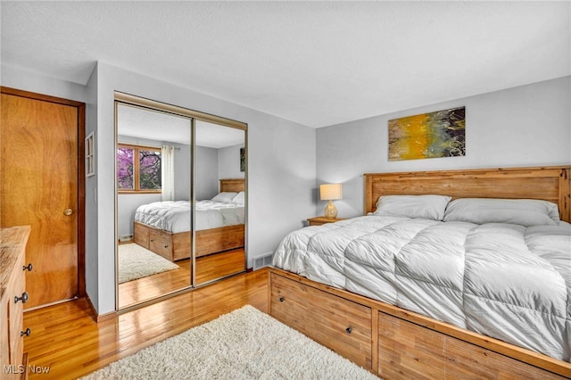 bedroom featuring a closet, wood finished floors, and visible vents
