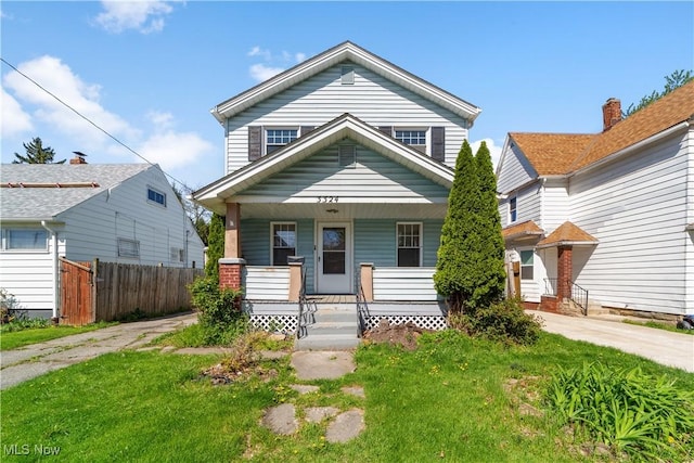 view of front of property featuring fence, covered porch, and driveway
