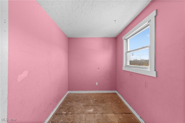 empty room with baseboards and a textured ceiling