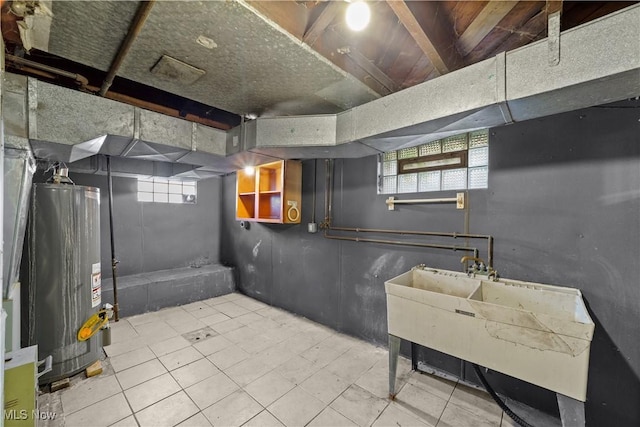 below grade area featuring water heater, tile patterned flooring, and a sink
