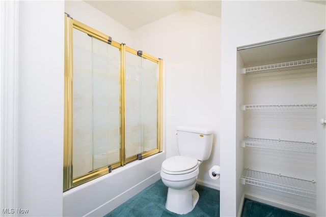 full bath with a walk in closet, toilet, enclosed tub / shower combo, baseboards, and vaulted ceiling