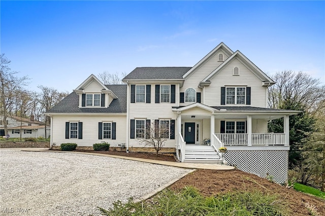 colonial house with a porch and roof with shingles