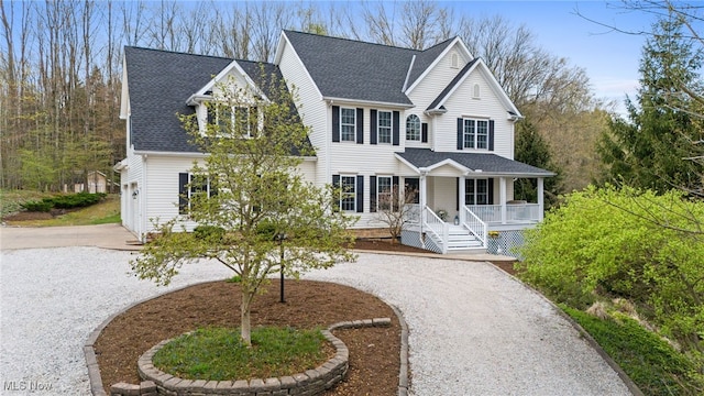 view of front of property with roof with shingles, curved driveway, and a porch