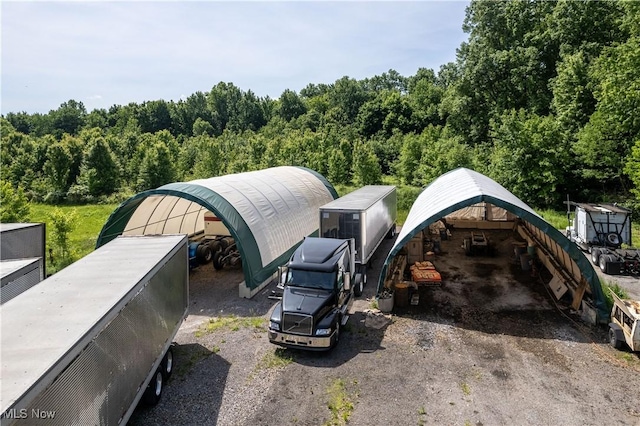 view of parking with a wooded view