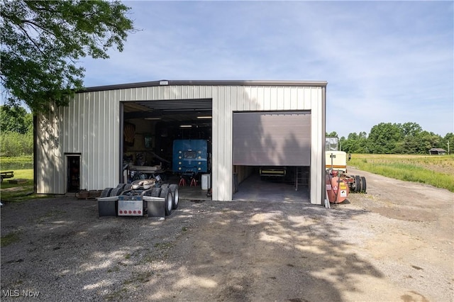 detached garage featuring dirt driveway