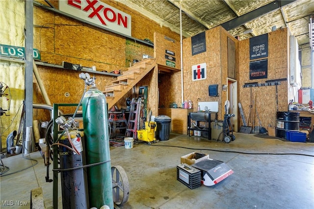 misc room with a high ceiling and unfinished concrete floors