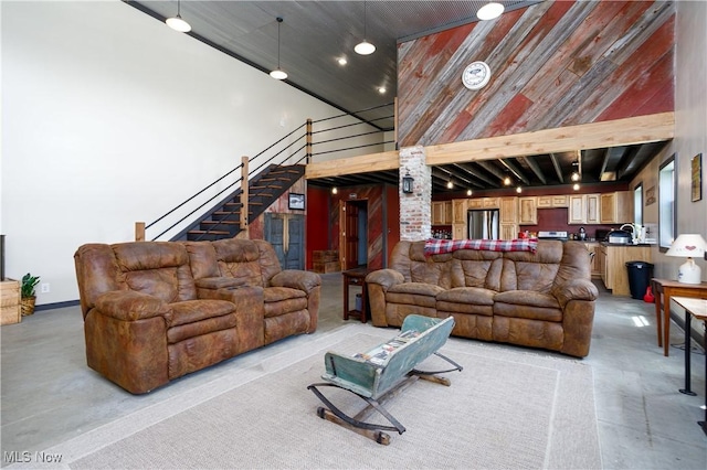 living area with stairway and a towering ceiling