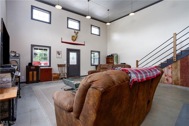 living room featuring stairway, finished concrete floors, and a towering ceiling