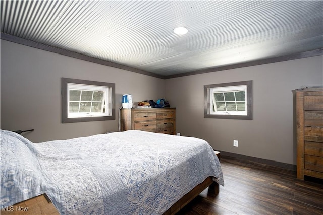 bedroom with baseboards and wood finished floors