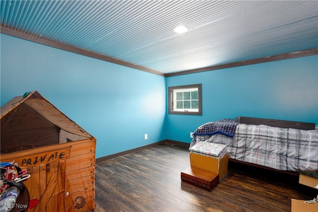 bedroom with baseboards and wood finished floors