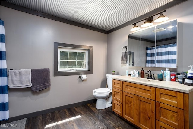 full bath featuring a shower with curtain, wood finished floors, vanity, baseboards, and toilet