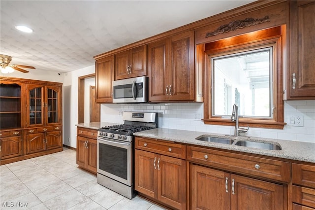 4160 Cambridge Ave, Lorain, OH 44053 - kitchen with light stone counters, a sink, appliances with stainless steel finishes, and tasteful backsplash