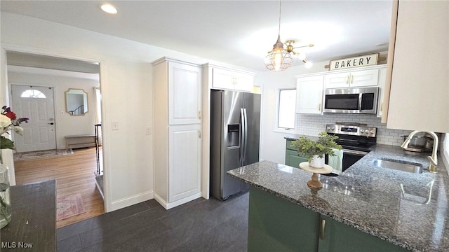 22322 Westwood Rd, Fairview Park, OH 44126 - kitchen with decorative backsplash, appliances with stainless steel finishes, a sink, a chandelier, and white cabinetry