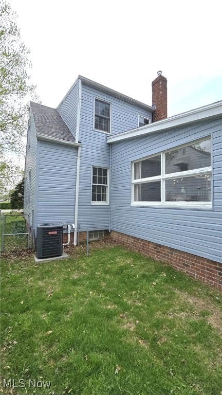 22322 Westwood Rd, Fairview Park, OH 44126 - back of property featuring a yard, fence, central AC unit, and a chimney