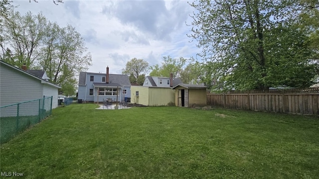 22322 Westwood Rd, Fairview Park, OH 44126 - back of property with a patio, a shed, a fenced backyard, an outdoor structure, and a yard