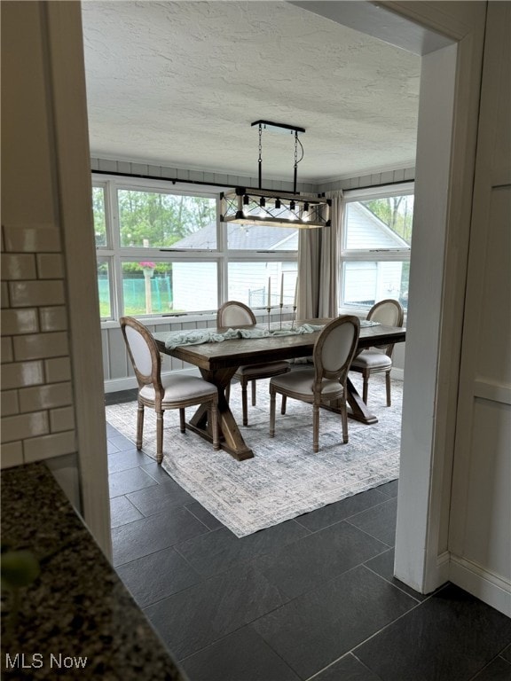 22322 Westwood Rd, Fairview Park, OH 44126 - dining area featuring baseboards, dark tile patterned floors, rail lighting, and a textured ceiling