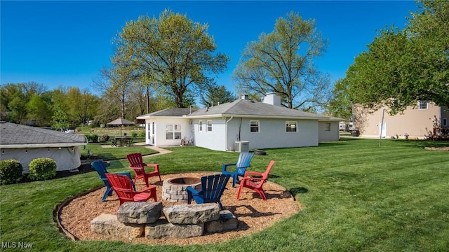 5130 Bateson Dr NE, Thornville, OH 43076 - rear view of property featuring an outdoor fire pit, stucco siding, a chimney, a lawn, and central air condition unit