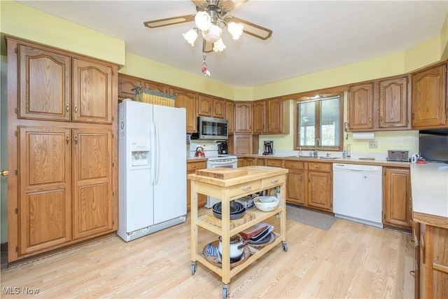 4561 Industry Rd, Ravenna, OH 44266 - kitchen with white appliances, brown cabinets, a sink, and light wood-style floors
