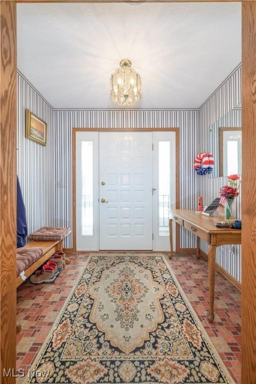 4561 Industry Rd, Ravenna, OH 44266 - entrance foyer with an inviting chandelier and brick floor