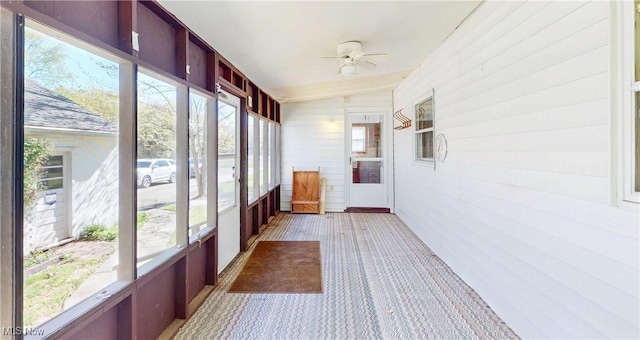 unfurnished sunroom with ceiling fan