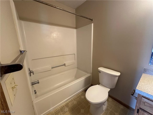 bathroom with vanity, baseboards, tile patterned floors, toilet, and washtub / shower combination