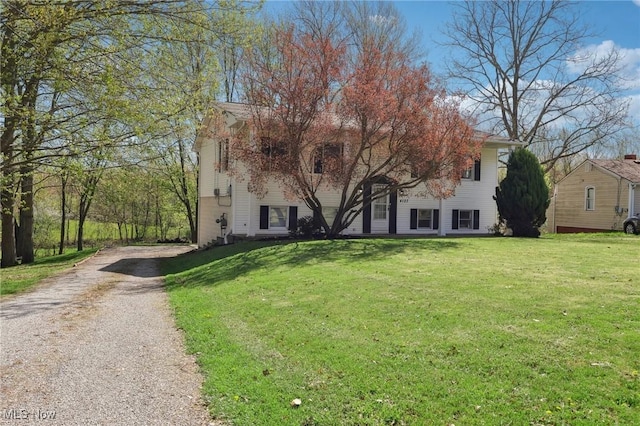 view of front facade featuring dirt driveway and a front yard