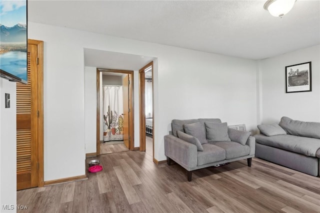 living area with baseboards and wood finished floors